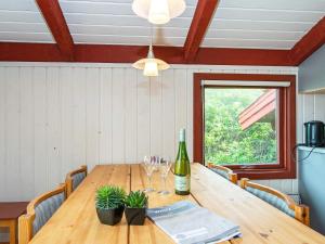 een eettafel met een fles wijn en glazen bij Holiday home Hvide Sande CXI in Bjerregård
