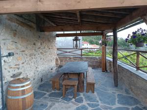 a patio with a wooden table and a barrel at Casa da Ana - Um refúgio na montanha in Arouca