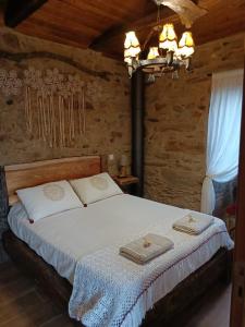 a bedroom with a bed with two towels on it at Casa da Ana - Um refúgio na montanha in Arouca