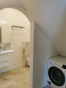 ein Bad mit einer Waschmaschine und einem Trockner im Zimmer in der Unterkunft Beach Lounge Luxory Apartments in Klaipėda