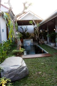 een tuin met een vijver voor een huis bij Grand Marto Hotel in Yogyakarta