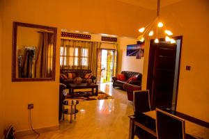 MODERN LUXURIOUS 2BEDS HOUSE IN KAMPALA CITY CTR في كامبالا: غرفة معيشة مع أريكة وطاولة