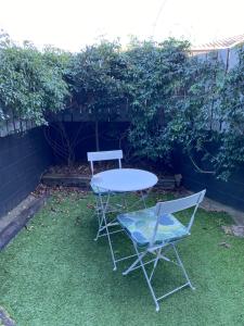 a table and two chairs sitting in the grass at Bar Harbor in Papamoa