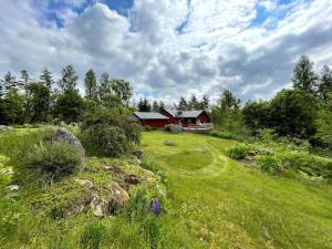 a house in the middle of a grassy field with a building at 8 person holiday home in ULRIKA-By Traum in Rimforsa