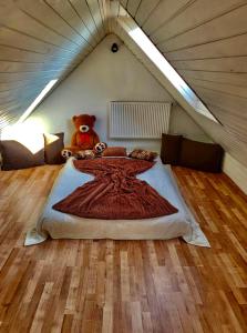a teddy bear sitting on a bed in a attic at HARMONY Apartments in Rajecké Teplice