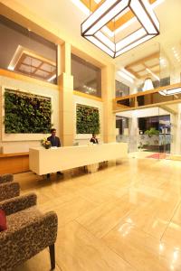 a lobby with two people sitting at a reception desk at Ginger Kochi MG Road in Cochin