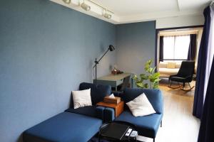 a blue living room with a couch and a table at Glass Shiseikan in Sapporo