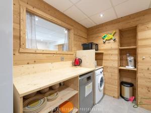 a log cabin kitchen with a washer and dryer at Chalet cosy avec sauna, piscine bio, proche lac et ski à Gérardmer - FR-1-589-408 in Gérardmer