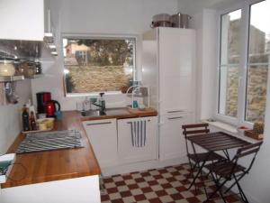 una cocina con armarios blancos, fregadero y 2 sillas en Villa Wimereux, 4 pièces, 6 personnes - FR-1-675-7, en Wimereux