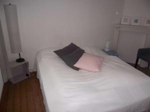 białe łóżko z dwoma poduszkami w obiekcie Maison cosy à 200m de la plage, 3 ch, terrasse, WiFi, proche centre, idéale pour famille - FR-1-675-7 w mieście Wimereux