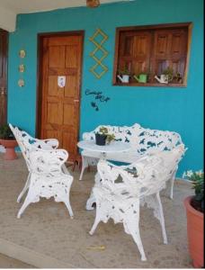 Habitación con mesa, sillas y pared azul. en Fazenda Terra Bonita - Passeios a Cavalo e Trilhas, en Serra de São Bento
