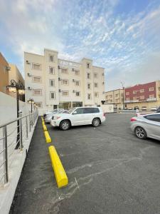 a parking lot with cars parked in front of a building at فندق اريف in Abha