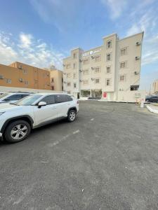 a white car parked in a parking lot in front of a building at فندق اريف in Abha