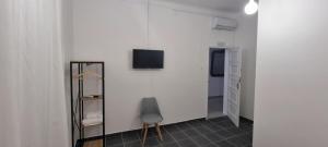 a room with a chair and a television on a wall at Casa Al'entejo in Ferreira do Alentejo