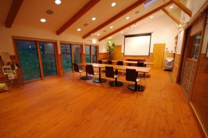 a conference room with a table and chairs and a screen at PICA Yamanakako Village in Yamanakako