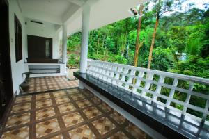 a porch of a house with a view of the forest at Spring and Valley View in Thekkady
