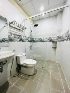 a white bathroom with a toilet and a sink at MIDMOST C22 Apartment in Can Tho