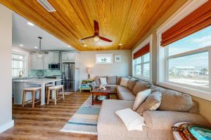 a living room with a couch and a kitchen at Cornerstone Beachside Cottage in Mexico Beach