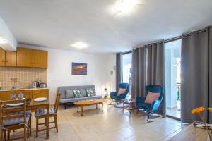a living room with a couch and chairs and a table at D & E APARTMENTS in Skiathos Town