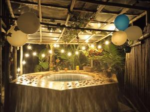 bañera de hidromasaje en una habitación con luces y globos en Paraíso Glamping La Vega, en La Vega