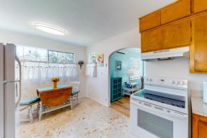 uma cozinha com electrodomésticos brancos e uma mesa em Waldport Bungalow em Waldport
