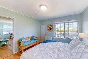 a bedroom with a white bed and a window at Waldport Bungalow in Waldport