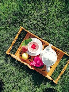 a wooden tray with a tea set on the grass at Geniş Bahçeli Barbekülü Kır Evi KOZALAK EVLERİ in Ortaca