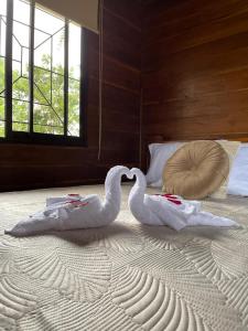 two swans laying on top of a bed at Cabañas Don Ramiro in Colonia Dos Ríos