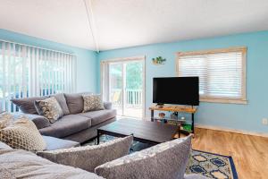 a living room with a couch and a tv at Flip Flop Inn in Dauphin Island