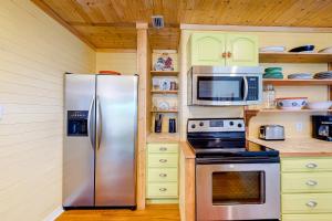 a kitchen with a stainless steel refrigerator and microwave at Flip Flop Inn in Dauphin Island