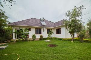 a house with a lawn in front of it at Chagga farm house in Moshi