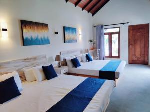 una camera da letto con due letti e una porta con una finestra di Anukama Resort a Nilaveli