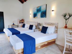 two beds in a room with blue and white at Anukama Resort in Nilaveli