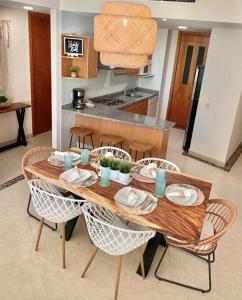 a wooden table with chairs in a kitchen at Vista al Lago con balcón en Mayan Lakes in Acapulco