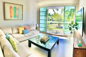 a living room with a couch and a coffee table at Vista al Lago con balcón en Mayan Lakes in Acapulco