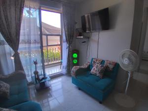 ein Wohnzimmer mit einem blauen Sofa und einem Fenster in der Unterkunft Apartamento Ricaurte - KASSANJA in Ricaurte