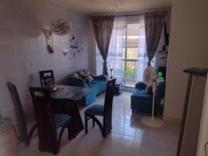 ein Wohnzimmer mit einem blauen Sofa und einem Tisch in der Unterkunft Apartamento Ricaurte - KASSANJA in Ricaurte
