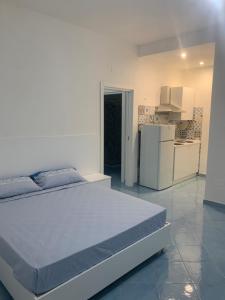 1 dormitorio con 1 cama y nevera blanca en Maison emi en Montecorice