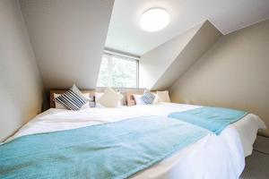 a bedroom with a large bed in a attic at The BASE in Otaru