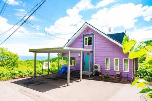 a pink house with a blue roof at The BASE in Otaru