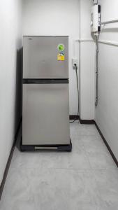 einen Kühlschrank in einem Zimmer mit einer Wand in der Unterkunft APARTMENT A4 DINDAENG in Bangkok