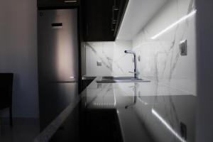 a kitchen with a sink and a refrigerator at Drebos Apartments in Lazaráta +31 photos