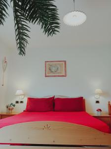 a bedroom with a large bed with red pillows at Camere Nordest Sudest- Conca Agordina in Agordo