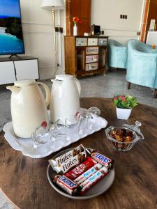 uma mesa com um bule de chá e uma bandeja com snacks em Diaara Hotel Appartments em Khamis Mushayt