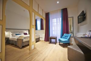 a hotel room with a bed and a blue chair at Hotel Elch Boutique in Nuremberg