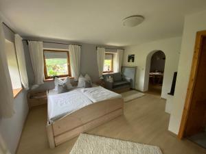 a bedroom with a bed and a couch and a chair at Kienberghof in Inzell