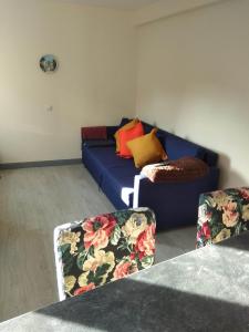 ein Wohnzimmer mit einem blauen Sofa und 2 Stühlen in der Unterkunft APARTAMENTO PIRAGUAS in Les Arriondes