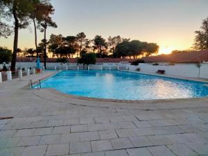a large swimming pool with a sunset in the background at La Casa del Colmao in Ávila
