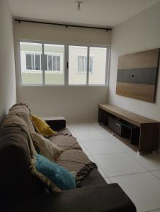 ein Wohnzimmer mit Sofa und Fernseher in der Unterkunft Apto Charmoso Bosque Heliópolis in Garanhuns + 20 Fotos