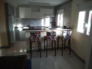 a kitchen with two bar stools with flowers on them at APARTAMENTO PIRAGUAS in Arriondas